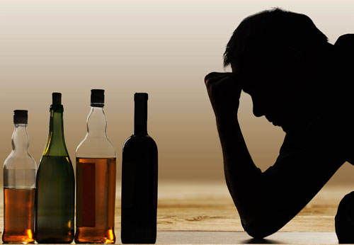silhouette-of-man-in-front-of-several-bottles-of-alcohol